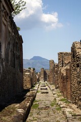 Fototapeta na wymiar Pompeii, Italy, June 26, 2020 one of the main streets of the Roman city found after excavations following the eruption of the volcano Vesuvius in 79 AD.