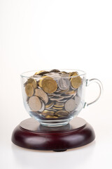 Coins in transparent cup glass.