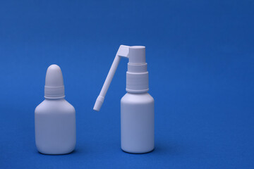 Nasal spray and throat spray on a blue background. copy space