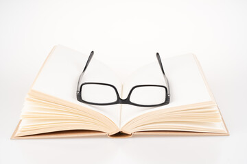 Book and black spectacle with close up view.