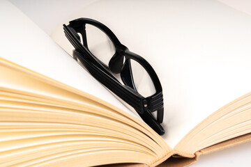 Book and black spectacle with close up view.