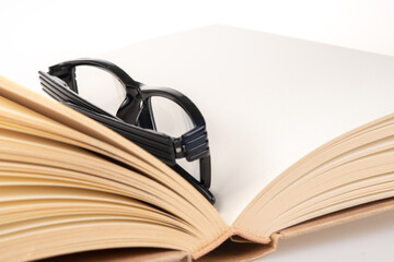 Book and black spectacle with close up view.