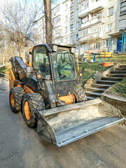Fototapeta na wymiar Small front-end loader for loading and unloading on city streets.