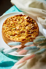 Apple or pear pie, tart with caramel nuts on blue table with sunlight