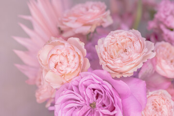 A lush bouquet of light pink, purple, peach colour, white cute delicate small roses of different sizes, flowers. Close-up