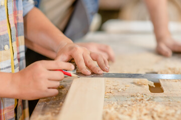 Fototapeta na wymiar Father teaches son carpentry at a workshop