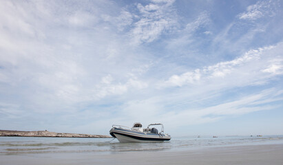 Langebaan Lagoon, South Africa. A Beautiful tourist destination with rocky coastline and speed boat with wispy cloud blue sky.