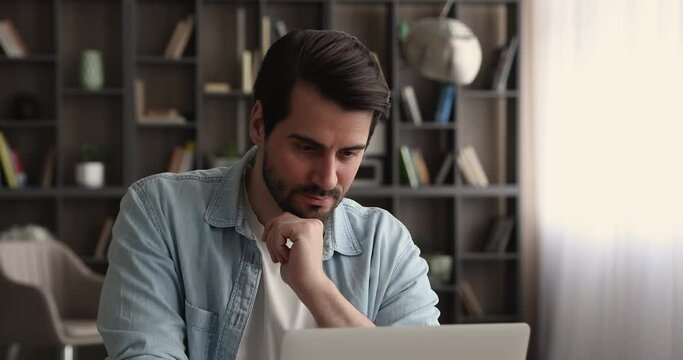 Thoughtful young businessman manager employee looking in distance, thinking on new project development, considering problem solution or searching for inspiration, working on computer at home office.