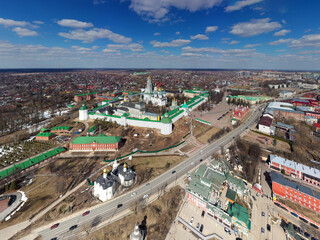 Fototapeta premium a panoramic view of the golden towers and ancient architectural solutions of the Trinity-Sergius Lavra in Sergiev Posad on a sunny spring day filmed from a drone 