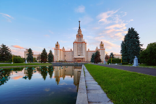 Wide angle panoramic view of sunset campus of Moscow university  under dramatic sky in spring with water reflections