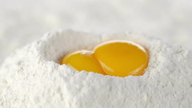 eggs in pile of flour close up. a bunch of flour with raw eggs. frame moves forward
