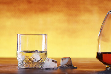 A glass of hard alcohol with ice on a bar counter. Whiskey with soda in a glass. Advertising...