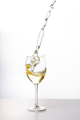 Weißwein im Weinglas mit weinspritzer aus dem glas