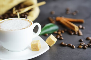 Bag of coffee. Coffee beans roasted on the table. Coffee beans with green leaves for cooking.