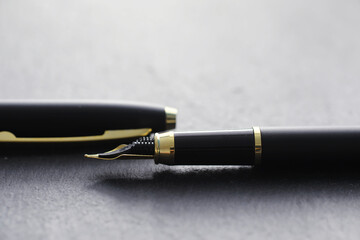 Office supplies on the table. A fountain pen. Business pen in the office on a stone surface.