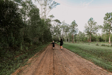 Obraz premium Mother and son playing together on remote country road