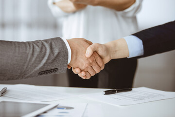 Obraz premium Business people shaking hands finishing contract signing, close-up. Business communication concept. Handshake and marketing