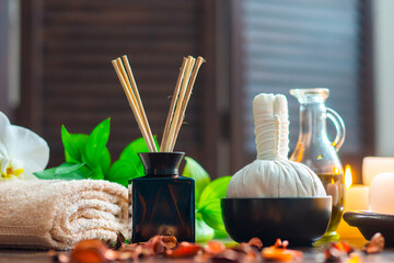 Spa background. Towel, candles, flowers, aroma sticks, massaging stones and herbal balls. Massage, oriental therapy, wellbeing and meditation.