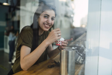 Fototapeta na wymiar Chica joven guapa tomando helado en la barra de una cafeteria