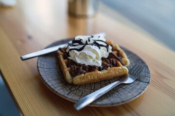 Gofre con nata y chocolate en la barra de una cafeteria