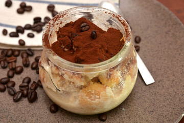 dolce tiramisù in boccale di vetro  tipico dolce italiano con formaggio mascarpone caffè cacao biscotti savoiardi