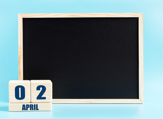 April 2th. Day 2 of month, Cube calendar with date, empty frame on light blue background. Place for your text. Spring month, day of the year concept