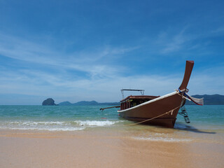 Fototapeta na wymiar Longtail Thai boat at the beautiful Blue Lagoon with crystal turquoise clear sea water, blue sky and rocks at the background. Amazing Thailand, wild beach with white sands (nobody)
