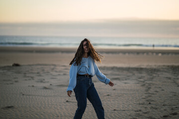 Chica joven en la playa sonriendo siendo feliz y sonriendo