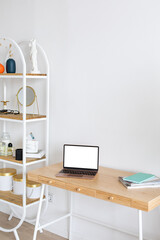 Laptop with blank white screen on the desk, mock up. Personal laptop computer on wood table in living room with modern interior.