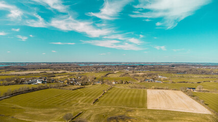 Drohnenfoto über die Felder von Schleswig-Holstein bei Sonnenschein mit einigen Wolken. Im...