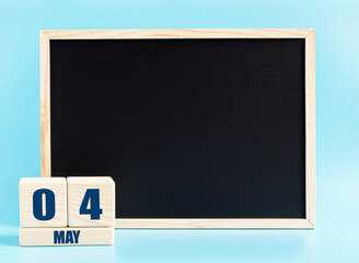 May 4. Day 4 of month, Cube calendar with date, empty frame on light blue background. Place for your text. Spring month, day of the year concept