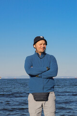 A man in a hat against the backdrop of a seascape.