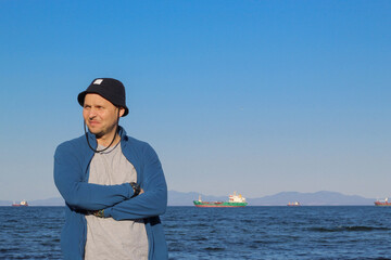 A man in a hat against the backdrop of a seascape.