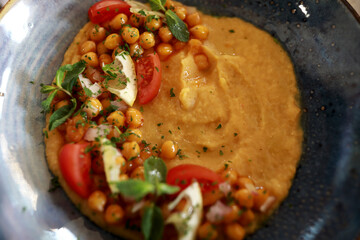 Hummus with tomatoes on plate