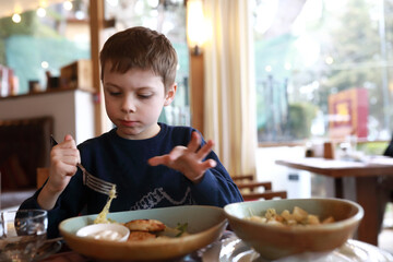 Kid eating pasta with cheese