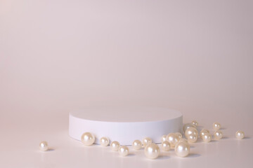 White podium on the white background with pearls. Podium for product, cosmetic presentation. Creative mock up. Pedestal or platform for beauty products.