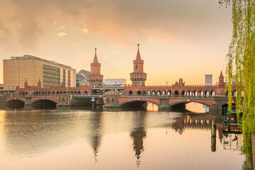 Obraz na płótnie Canvas Berlin skyline with Oberbaum Bridge and Spree River, at sunrise