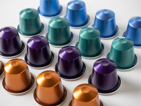 many aluminum coffee capsules are displayed in a row on a white background. Food pattern. Capsules for the coffee machine