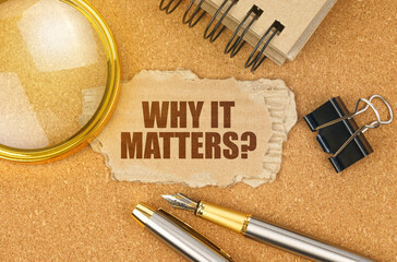 On the table are office items and a cardboard with the inscription - WHY IT MATTERS