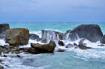 waves crash on stones.  blue sea