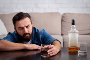 Sad depressed addicted drunk guy having problem, suffer from alcohol addiction