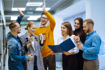 Group of young modern people working on project together. Business colleagues discuss financial...