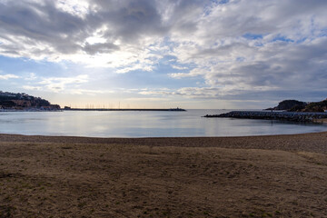 Empty sandy beach landscape on a quiet water scene under a cloudscape sky