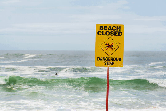 Beach closed sign for swimmers at the beach in Australia. Dangerous current and high waves