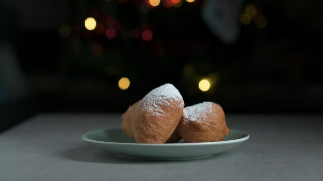Dusting deep fried doughnut balles with icing suger