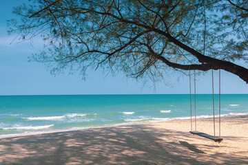 Turquoise blue sea view with swing at pine tree on beach, Nature background wallpaper