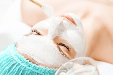 The girl's face covered with a cosmetic mask, close-up. Skin care, beautician, spa treatments, facial hygiene.