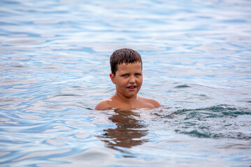 The boy swims in the water