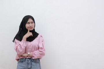 Young Muslim women put their clothes on their chins and feel confused in their choices. Beautiful asian woman with casual dress. Beautiful muslim women.