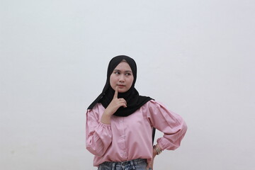 Young Muslim women put their clothes on their chins and feel confused in their choices. Beautiful asian woman with casual dress. Beautiful muslim women.